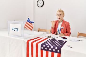 Poster - Beautiful caucasian woman working at political campaign surprised pointing with hand finger to the side, open mouth amazed expression.