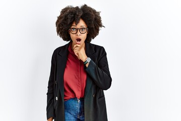 Sticker - African american woman with afro hair wearing business jacket and glasses looking fascinated with disbelief, surprise and amazed expression with hands on chin