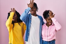 Group Of Three Young Black People Standing Together Over Pink Background Surprised With Hand On Head For Mistake, Remember Error. Forgot, Bad Memory Concept.