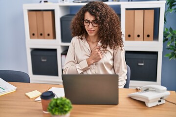 Sticker - Young hispanic woman business worker using laptop touching chest at office