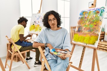 Sticker - Young hispanic woman at art studio looking sleepy and tired, exhausted for fatigue and hangover, lazy eyes in the morning.