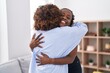 African american women mother and daughter hugging each other at home