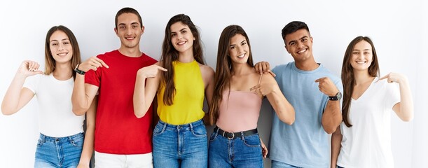 Sticker - Group of people wearing casual clothes standing over isolated background looking confident with smile on face, pointing oneself with fingers proud and happy.