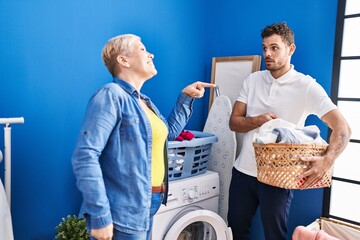 Sticker - Mother and son holding basket with clothes at laundry room