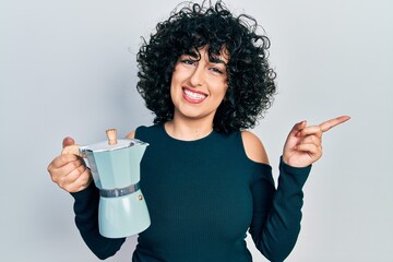 Canvas Print - Young middle east woman drinking italian coffee smiling happy pointing with hand and finger to the side