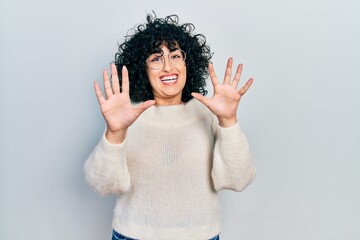 Poster - Young middle east woman wearing casual white tshirt afraid and terrified with fear expression stop gesture with hands, shouting in shock. panic concept.