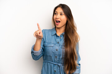 Wall Mural - asian pretty woman feeling shocked and surprised, pointing and looking upwards in awe with amazed, open-mouthed look