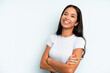 hispanic pretty woman laughing happily with arms crossed, with a relaxed, positive and satisfied pose