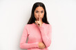 © kues1 - hispanic pretty woman looking serious and cross with finger pressed to lips demanding silence or quiet, keeping a secret