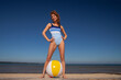young woman in swimsuit with beach ball