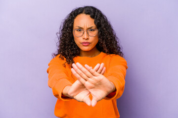 Young hispanic woman isolated on purple background standing with outstretched hand showing stop sign, preventing you.