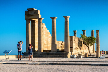 Wall Mural - Visitors making a photo of  temple of Athena Lindia in Lindos acropolis in Rhodes island in Greece