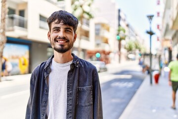 Poster - Young hispanic man smiling happy standing at the city.