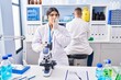 © Krakenimages.com - Young woman working at scientist laboratory covering mouth with hand, shocked and afraid for mistake. surprised expression