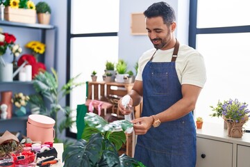 Sticker - Young hispanic man florist smiling confident watering plant at florist