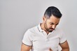 © Krakenimages.com - Young hispanic man with beard wearing casual clothes over white background with hand on stomach because indigestion, painful illness feeling unwell. ache concept.