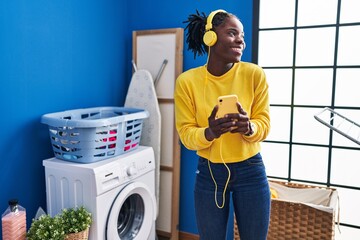 Sticker - African american woman liatening to music waiting for washing machine at laundry room