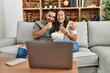 © Krakenimages.com - Young hispanic couple watching film and eating popcorn sitting on the sofa at home.
