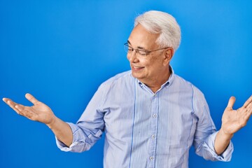 Canvas Print - Hispanic senior man wearing glasses smiling showing both hands open palms, presenting and advertising comparison and balance