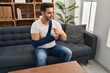 © Krakenimages.com - Young hispanic man with beard wearing arm on sling sitting at therapy consult pointing finger to one self smiling happy and proud