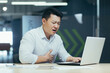 © Liubomir - Sick Asian businessman at work, man chest pain heart, overworked and depressed boss.