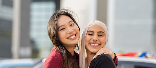 Portrait of two Asian Muslim businesswomen, Asian businesswomen or office workers, colleagues of diverse ethnic, intercultural and religious smiles accepting as colleagues in the organization.