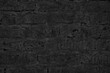 Old rough brick wall black texture. Abstract dark gloomy grunge background