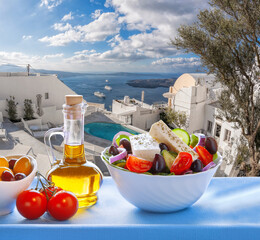 Wall Mural - Greek salad against tourist resort with swimming pool on Santorini island in Greece