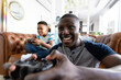 © Wavebreak Media - Image of african american father and son playing games on the console