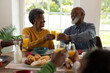 © WavebreakMediaMicro - Image of happy african american senior couple toasting with juice