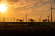 Gas-Pipeline und Windräder vor Sonnenuntergang