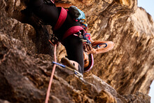 Senior Woman Climbing On Rocky Cliff
