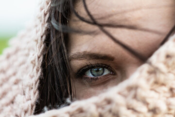 Wall Mural - close up portrait of a young woman eye. winter time scraf covered face