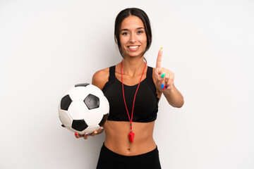 Wall Mural - hispanic pretty woman smiling and looking friendly, showing number one. soccer and fitness concept