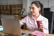 © ADDICTIVE STOCK - Joyful woman with coffee typing on laptop