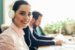 © ADDICTIVE STOCK - Woman in headphones working near colleagues