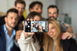 © ADDICTIVE STOCK - Cheerful diverse colleagues taking selfie in office