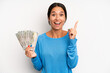 © kues1 - hispanic pretty woman feeling like a happy and excited genius after realizing an idea. dollar banknotes concept
