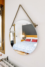 Round Mirror Hanging On Wall In Cozy Bedroom