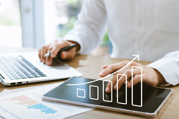 Businessman analyzing company's financial balance sheet working with digital augmented reality graphics. Businessman calculates financial data for long-term investment.