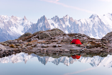 Wall Mural - Red tent on Lac Blanc lake coast in France Alps. Monte Bianco mountains range on background. Landscape photography, Chamonix.