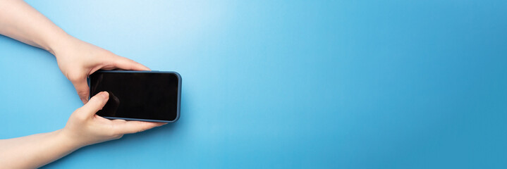 mobile app banner, female hand with phone on blue background top view