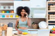 © kanpisut - woman using the mobile or smart phone in kitchen at home