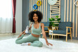 © kanpisut - Woman doing yoga at home in the living room. Woman is stretching in yoga at home. work out time