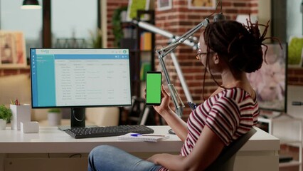 Poster - Young employee looking at greenscreen display on mobile phone, doing remote job at desk. Working with isolated mockup template, blank chroma key display and copyspace background. Tripod shot.