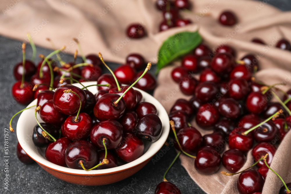 Bowl of tasty cherries on table, closeup