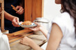 © DragonImages - Hands of young woman taking plate with fresh croissant she ordered in bakery