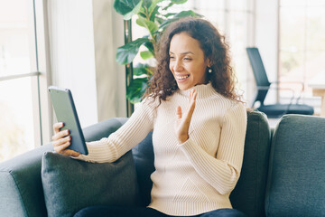 Latin woman video conference on tablet with happy feeling