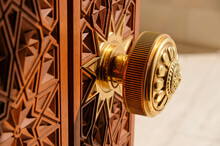 Round Door Handle With Ornament. Antique Handle On The Background Of A Wooden Door.