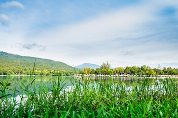 Wall Mural - Green grass beside the lake with Huay Tueng Thao Background